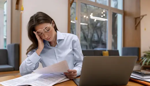 Profissional cansada revisando materiais de estudo de espanhol sem evoluir